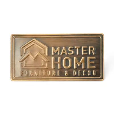 Custom embossed brass label attached to wooden furniture surface