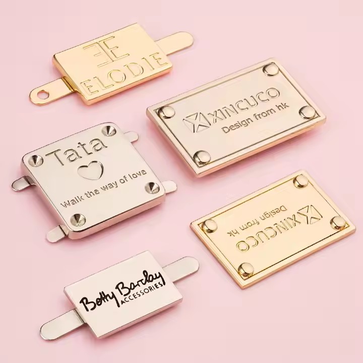 High-quality laser engraved metal tag with logo on a luxury handbag