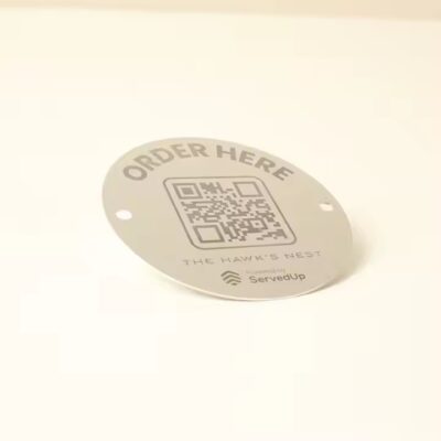 Weatherproof metal QR code label on a tree for plant identification outdoors
